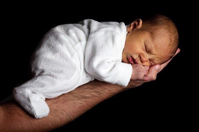 A baby sleeping on an arm.